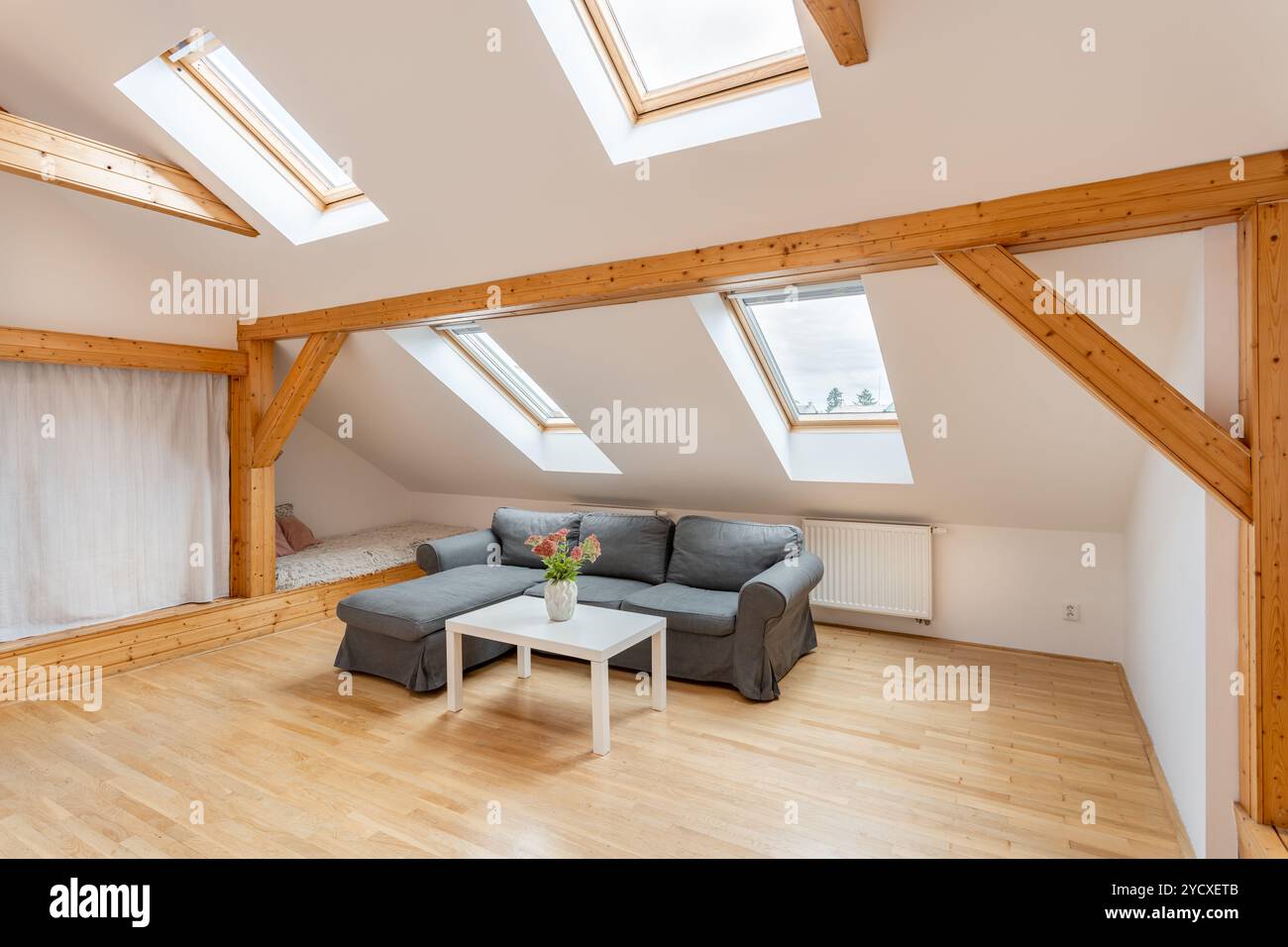 Ampio e luminoso soggiorno nell'attico con travi in legno Foto Stock