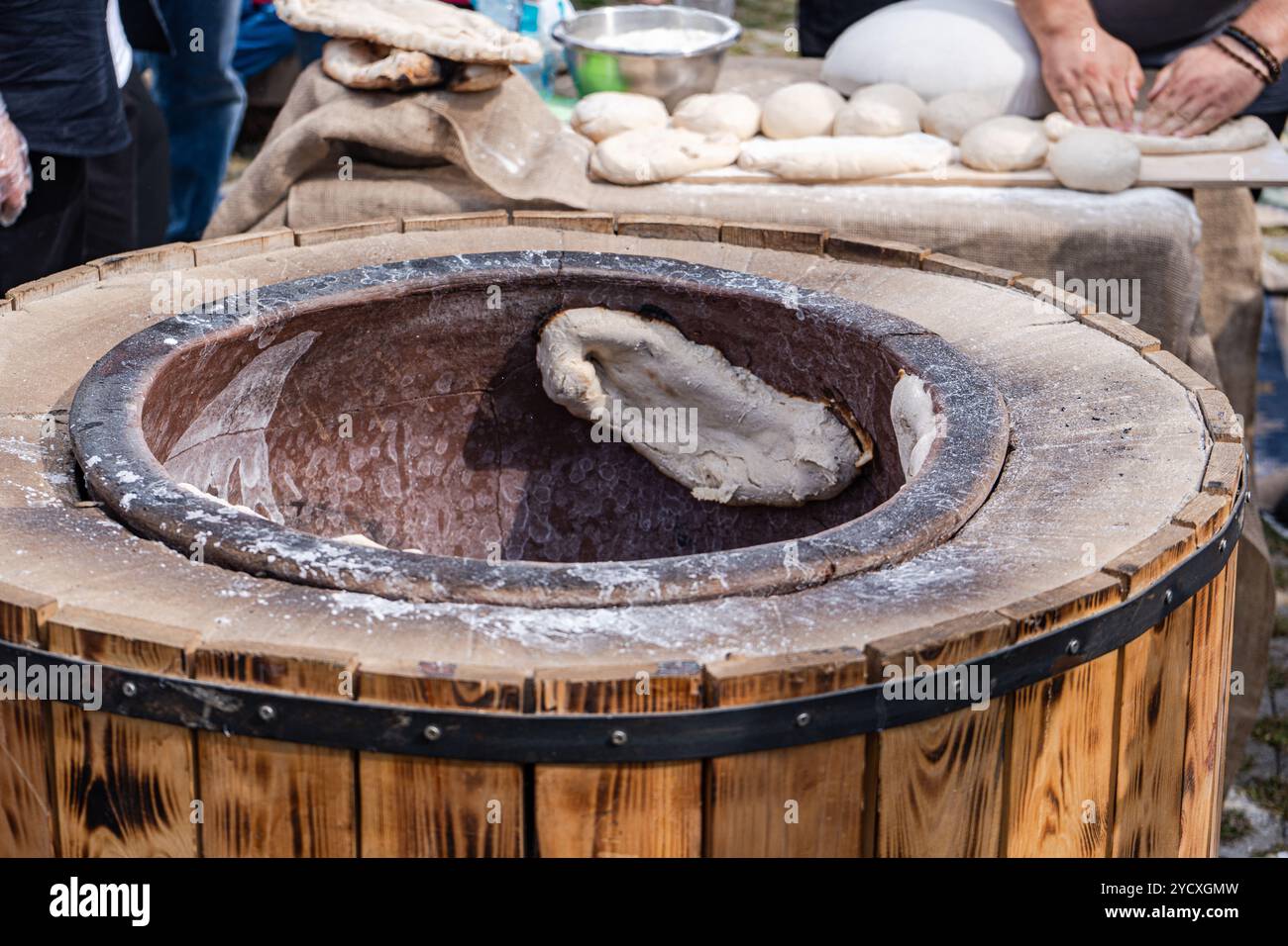 Catturando l'essenza della cultura culinaria georgiana, questa immagine mostra la tradizionale cottura di khachapuri e tonis puri, un pane al formaggio sapientemente co Foto Stock