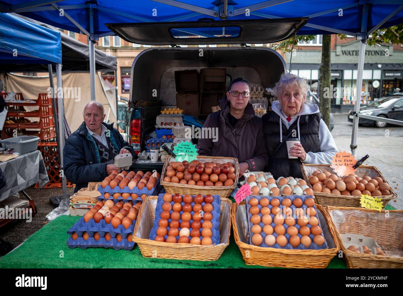 St Albans nell'Hertfordshire, Inghilterra, famiglia locale che vende uova all'aperto su un mercato invernale umido del sabato, Inghilterra, Regno Unito Foto Stock