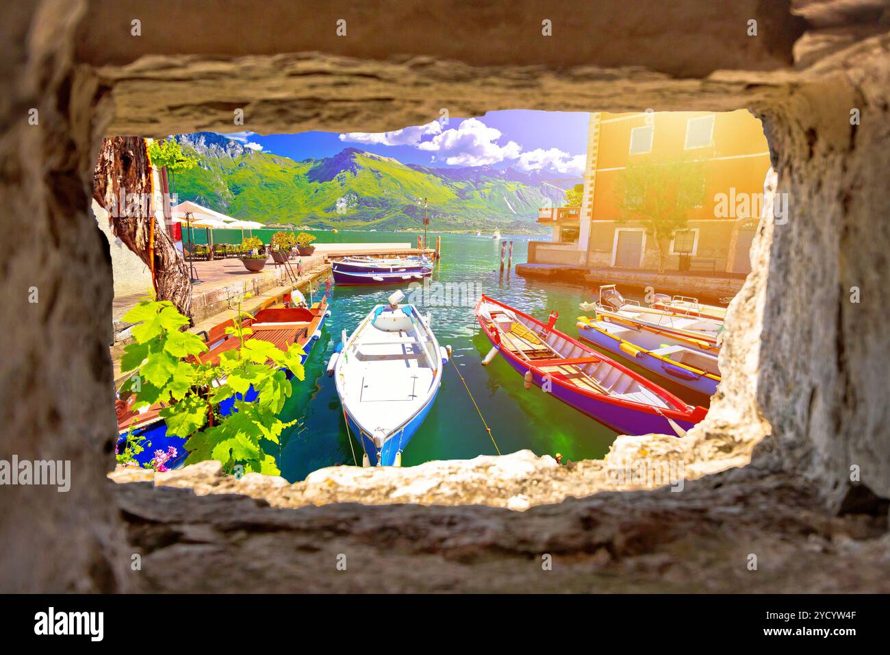 Limone sul Garda fronte mare turchese e vista delle barche dalla finestra in pietra Foto Stock