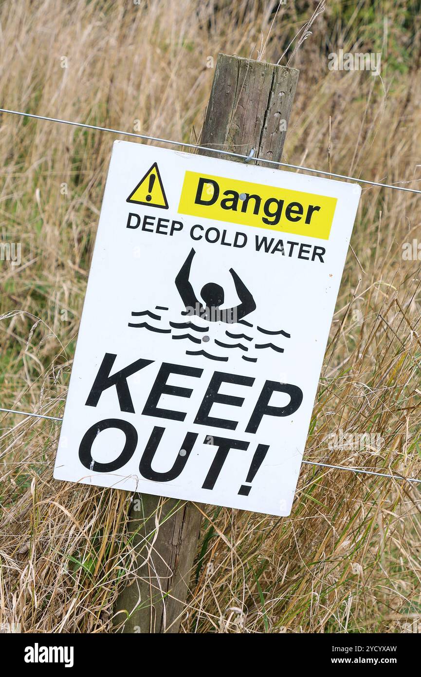 Un cartello che dice "pericolo acqua fredda profonda tenere fuori", Inghilterra, Regno Unito Foto Stock