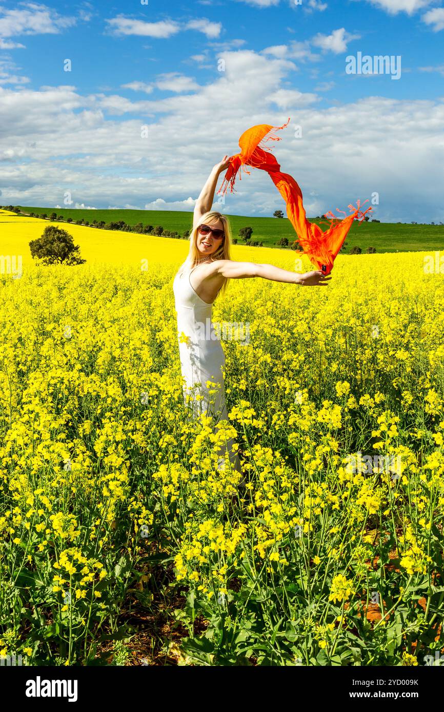 Donna nei campi di canola dorata Foto Stock