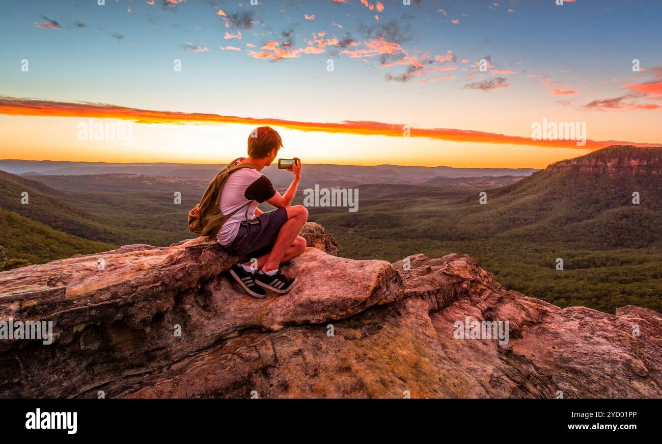 Escursionista maschile o escursionista che scatta foto del tramonto Foto Stock