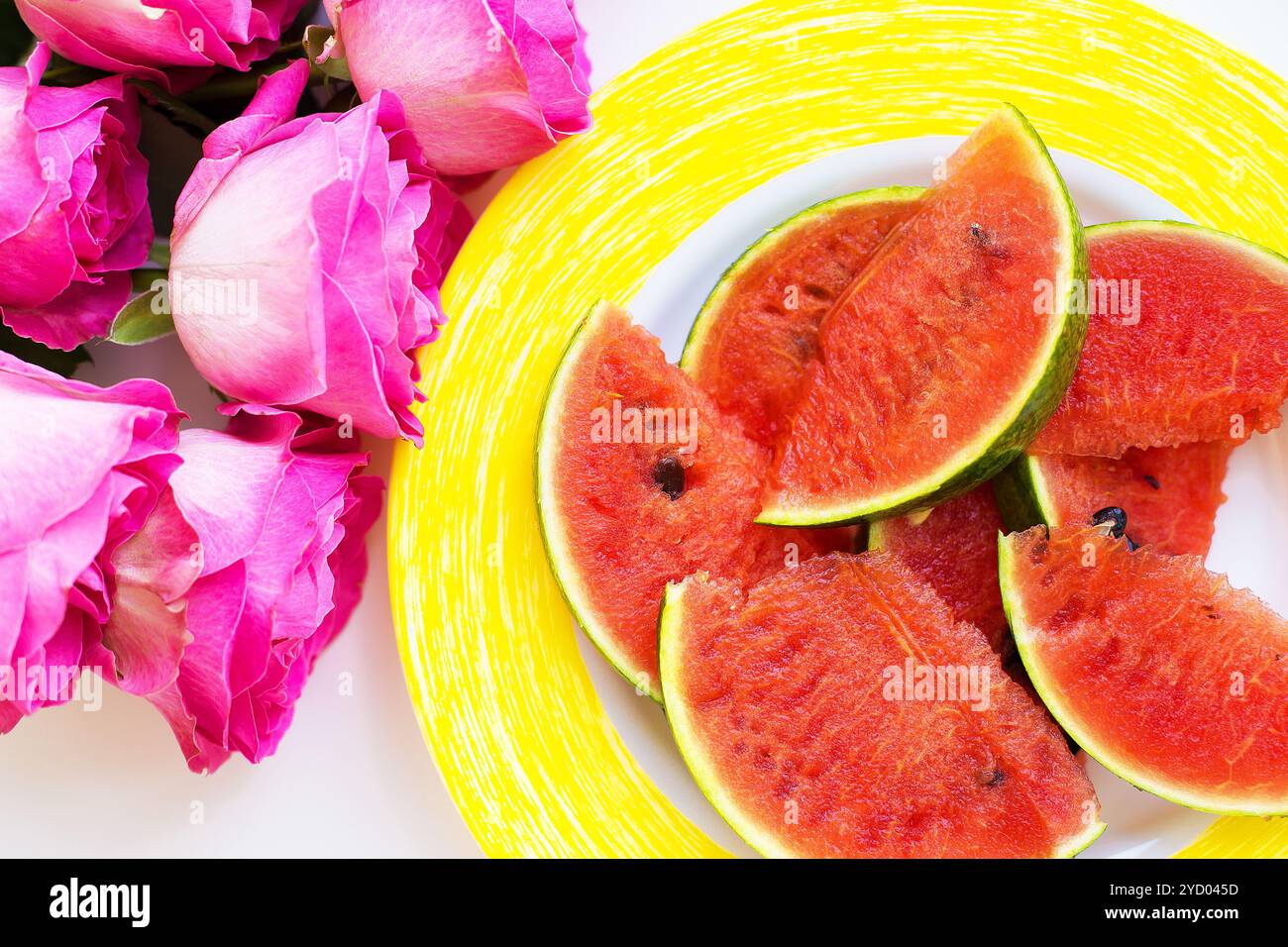 Bouquet di rose rosa sul tavolo con anguria Foto Stock