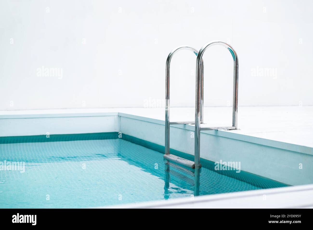 Corrimano in acciaio inox per scendere in piscina. Piscina con corrimano. Scala di una piscina. Ripresa orizzontale. Foto Stock