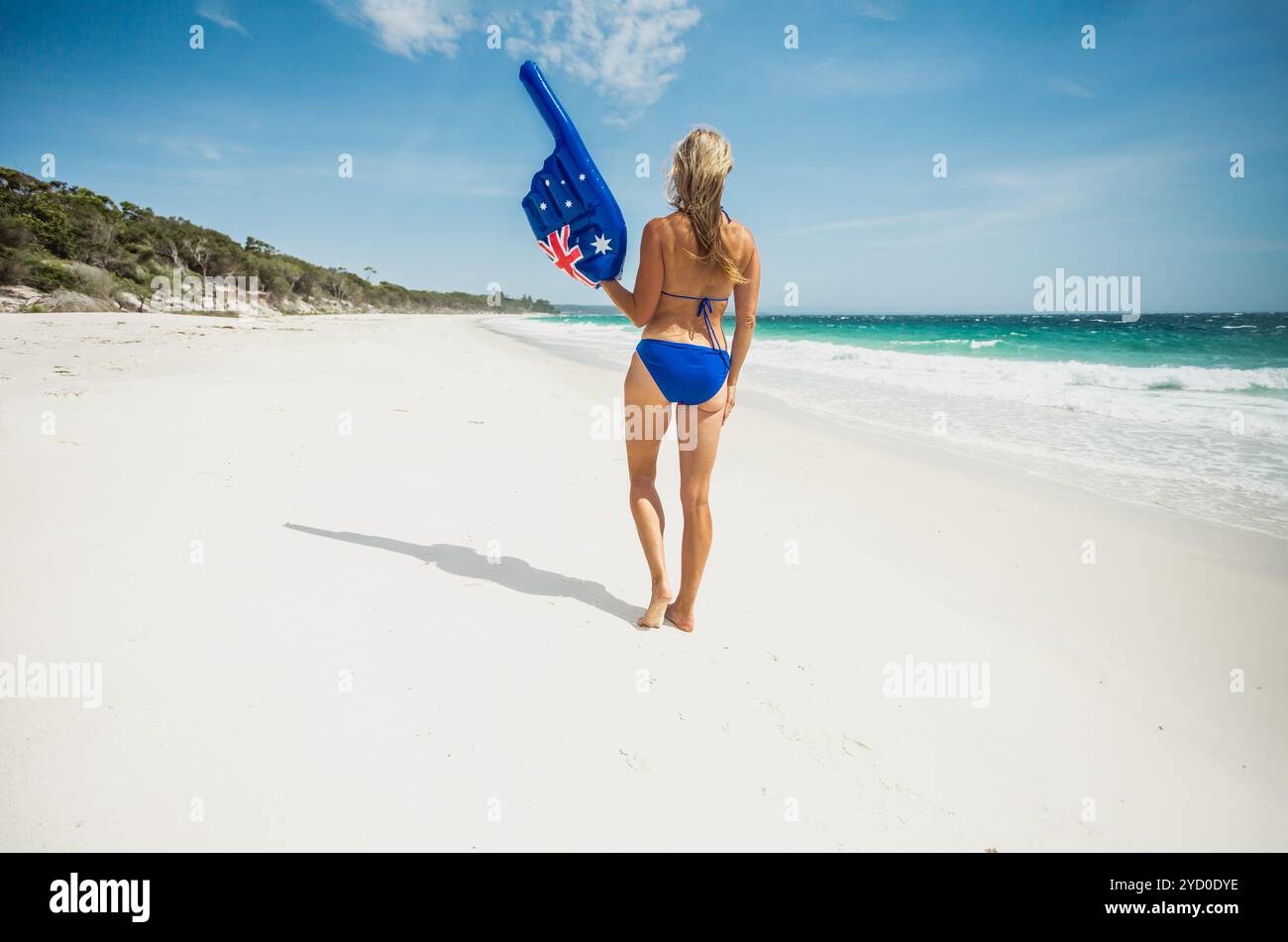 Donna bikini con un grande dito puntato sulla spiaggia in Australia Foto Stock