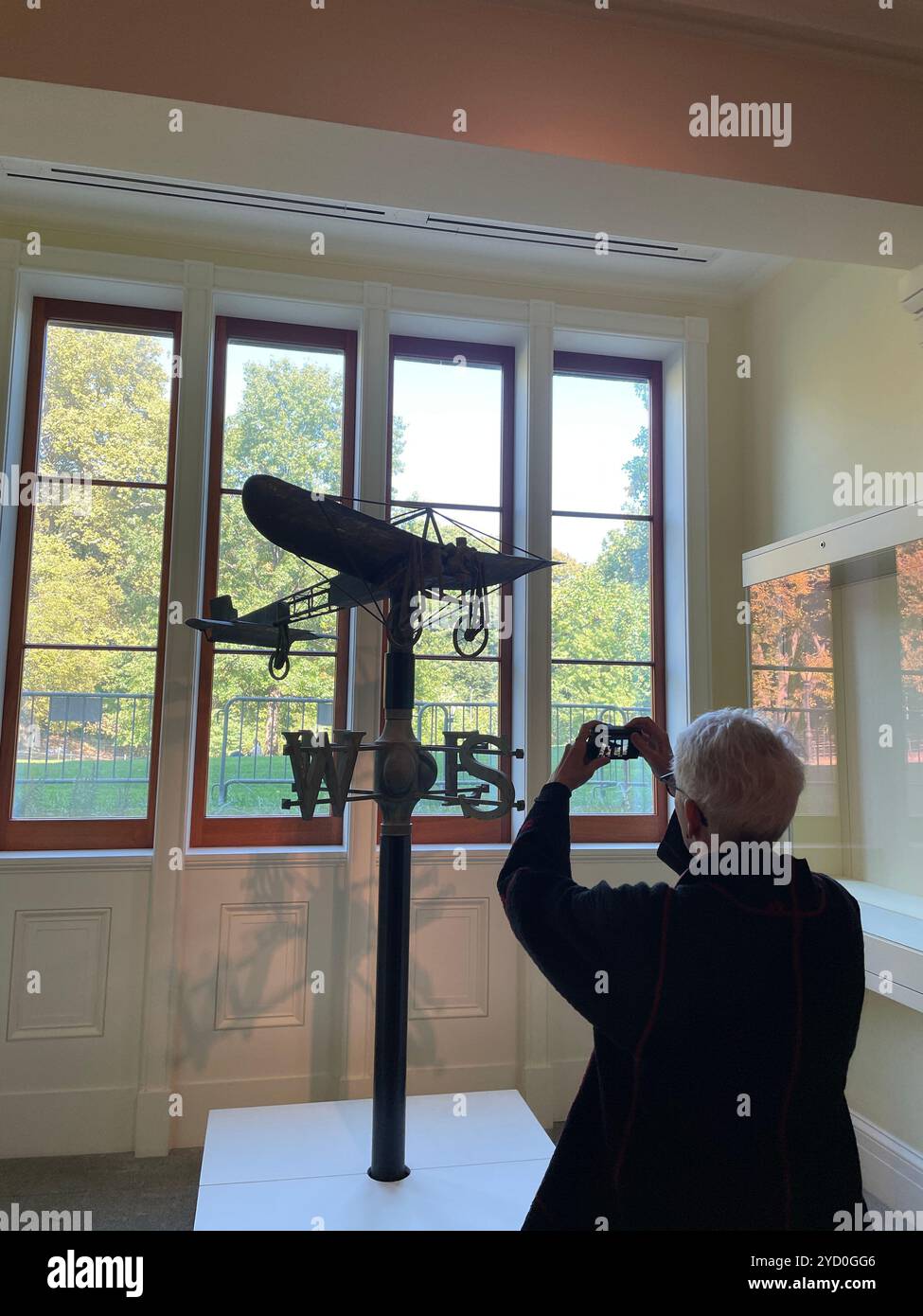 Senior Female Patron Takes a Photo of an Antique Weathervane , 2024, Metropolitan Museum of Art American Wing, NYC, USA - Immagine stock catturata con smartphone