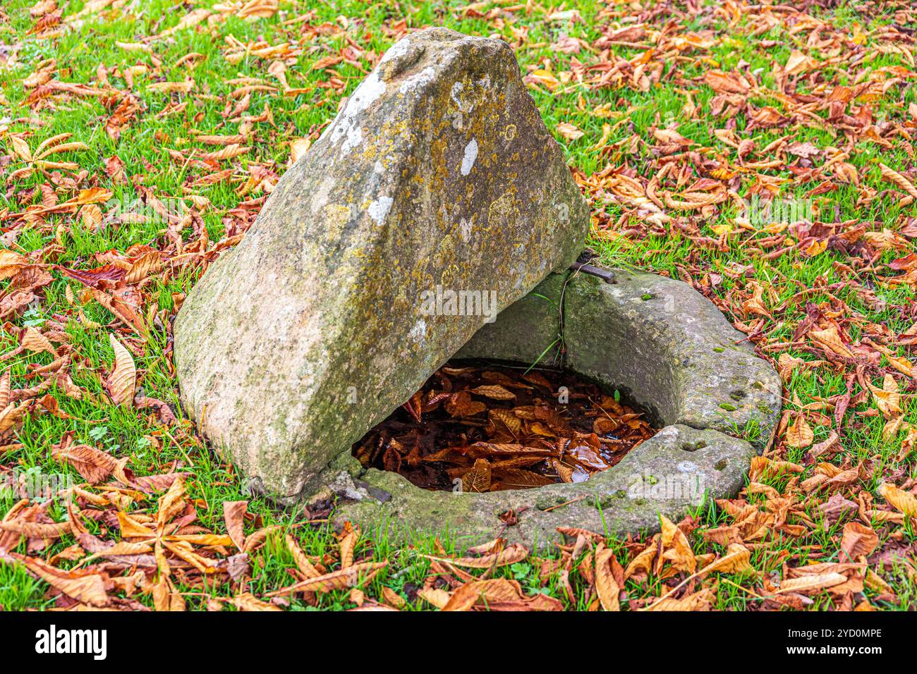 Un vecchio pozzo curioso sul verde nel villaggio Cotswold di Shilton, vicino a Burford, Oxfordshire, Inghilterra Regno Unito Foto Stock