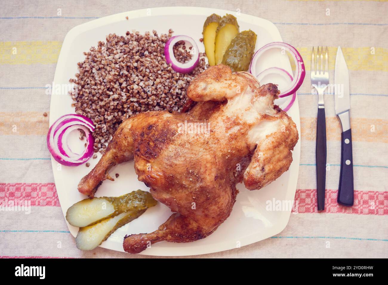 Cotta nel forno a condimenti il pollo con il grano saraceno. Cucina domestica. Il pollo al forno la carcassa. Pollo con grano saraceno, cipolle e cetrioli Foto Stock