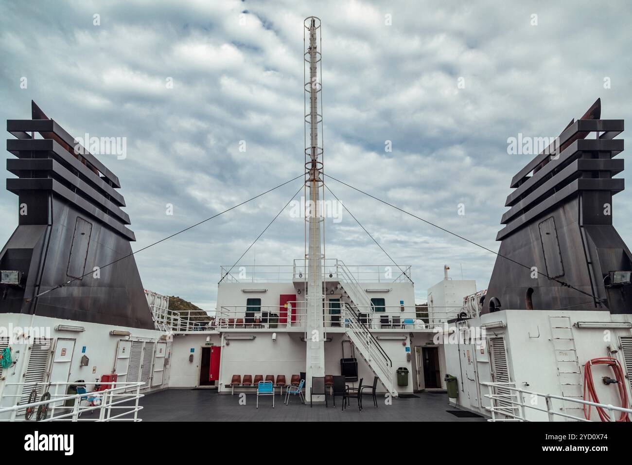 Il ponte di una nave passeggeri espone la sua architettura navale, sullo sfondo mozzafiato delle isole Lofoten, con nuvole che gettano ombre su t Foto Stock