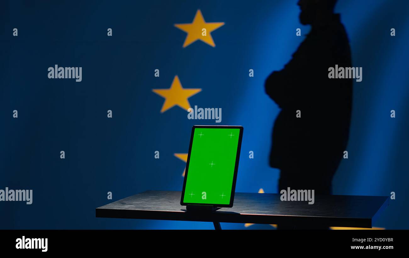 La divisione di controspionaggio dell'Unione europea utilizza una tavoletta con schermo verde per proteggersi dalla propaganda che colpisce le elezioni. Servizio di sicurezza dell'UE per la salvaguardia della democrazia online utilizzando un dispositivo di mockup, telecamera A Foto Stock