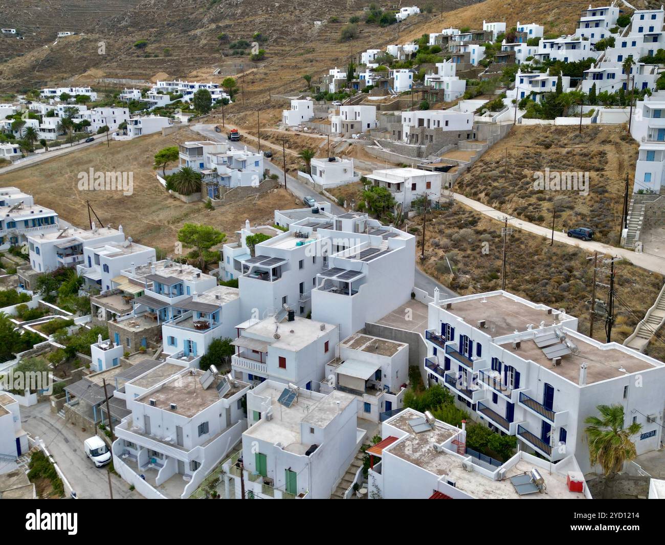 Le tradizionali case bianche delle Cicladi scendono lungo la collina nelle isole greche, mostrando la tipica architettura e stile di vita mediterranei Foto Stock