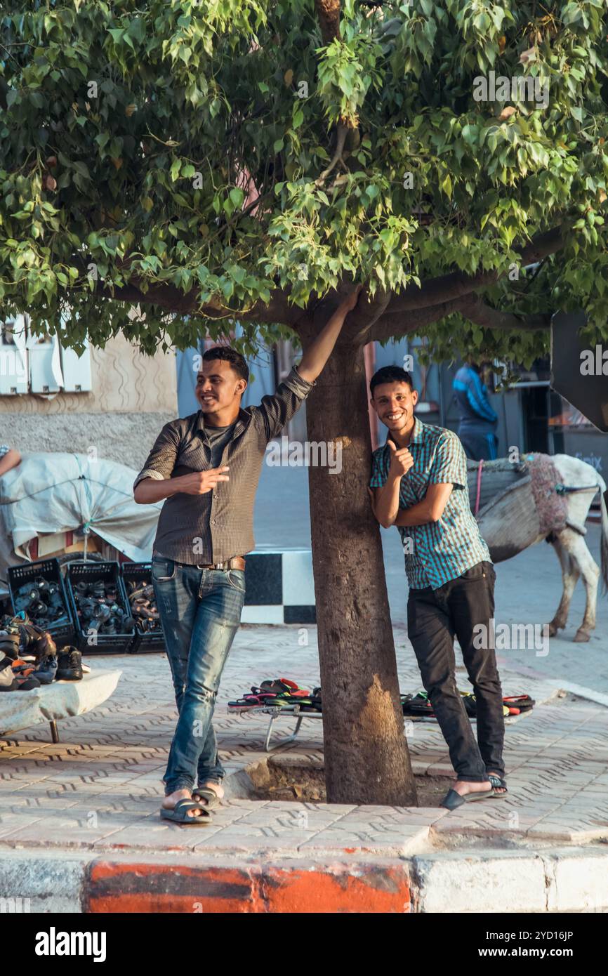 Countryside, Marocco, 23 luglio 2019: Due amici che si divertono sotto un albero in una strada vivace della vibrante città del Marocco Foto Stock