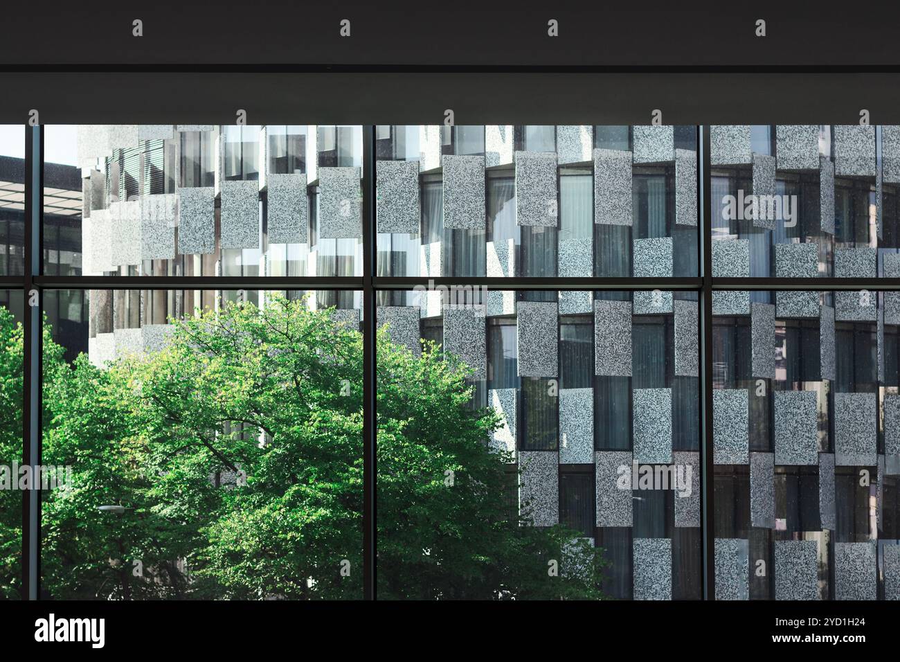 Edificio incorniciato da finestre che mostrano dettagli architettonici e paesaggi circostanti. L'edificio è visibile attraverso una finestra Foto Stock