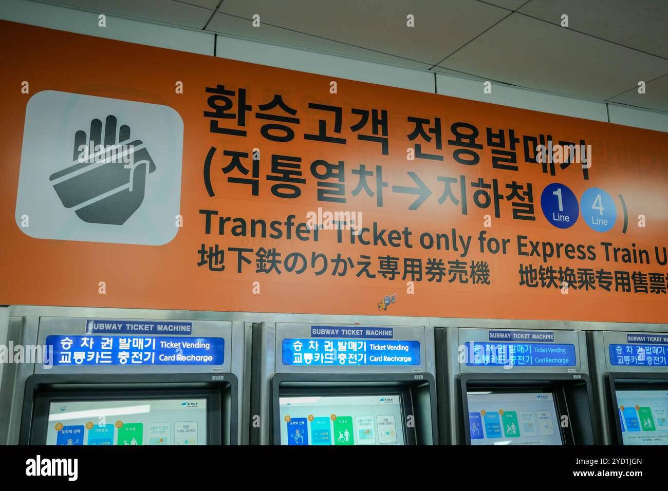 Cartello con scritto Transfer Ticket Only for Express Train. Il segno è in una lingua straniera. Ci sono tre distributori automatici nell'immagine Foto Stock