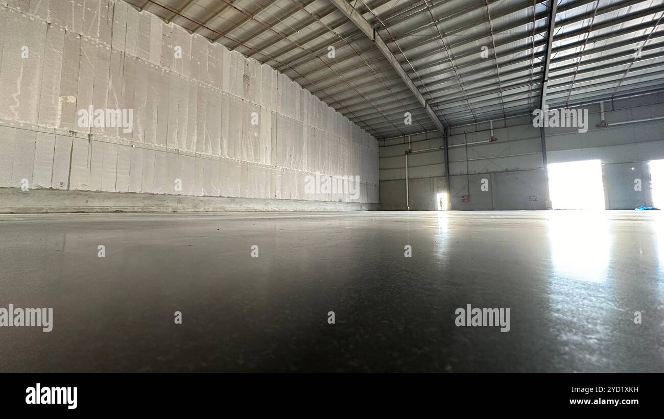 Edificio industriale o fabbrica moderna per impianti di produzione o grandi magazzini, pavimento in calcestruzzo lucidato pulito e spazio per l'identificazione Foto Stock