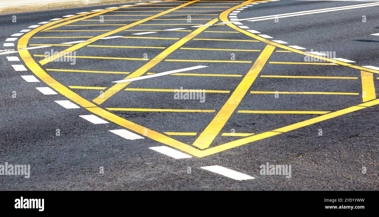 Linee stradali bianche e gialle sull'asfalto Foto Stock