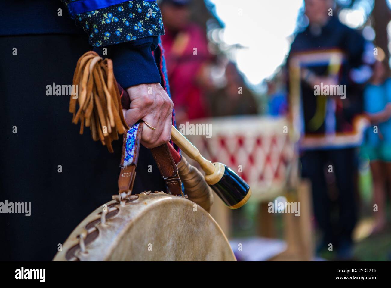 La donna in abiti cerimoniali tiene il suo tamburo sacro Foto Stock