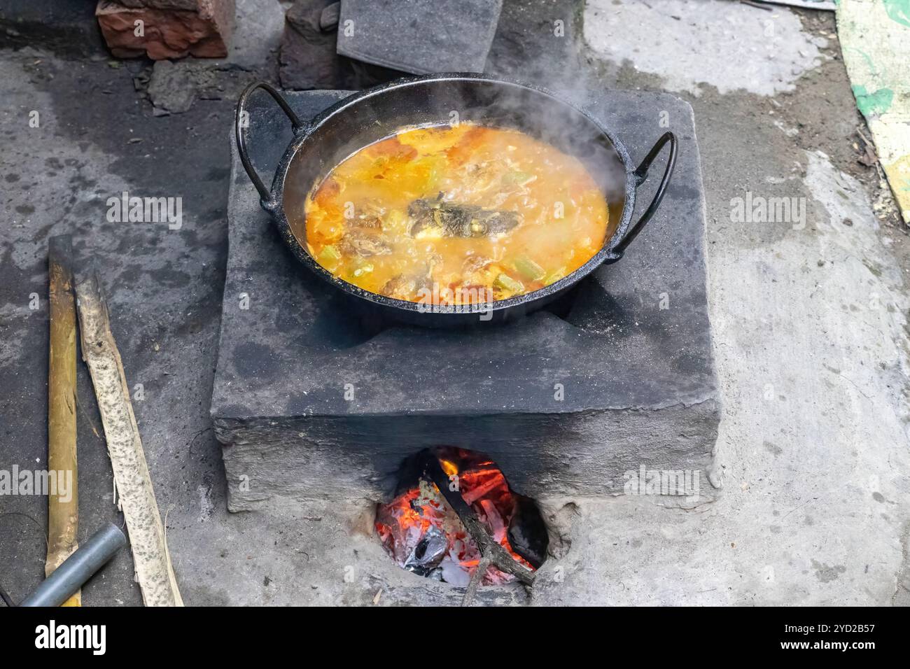 Il curry di pesce Rui sta cucinando su una tradizionale stufa di fango in una cucina del villaggio del Bangladesh. Stufe in argilla e alimentate con legno, comunemente utilizzate da Foto Stock