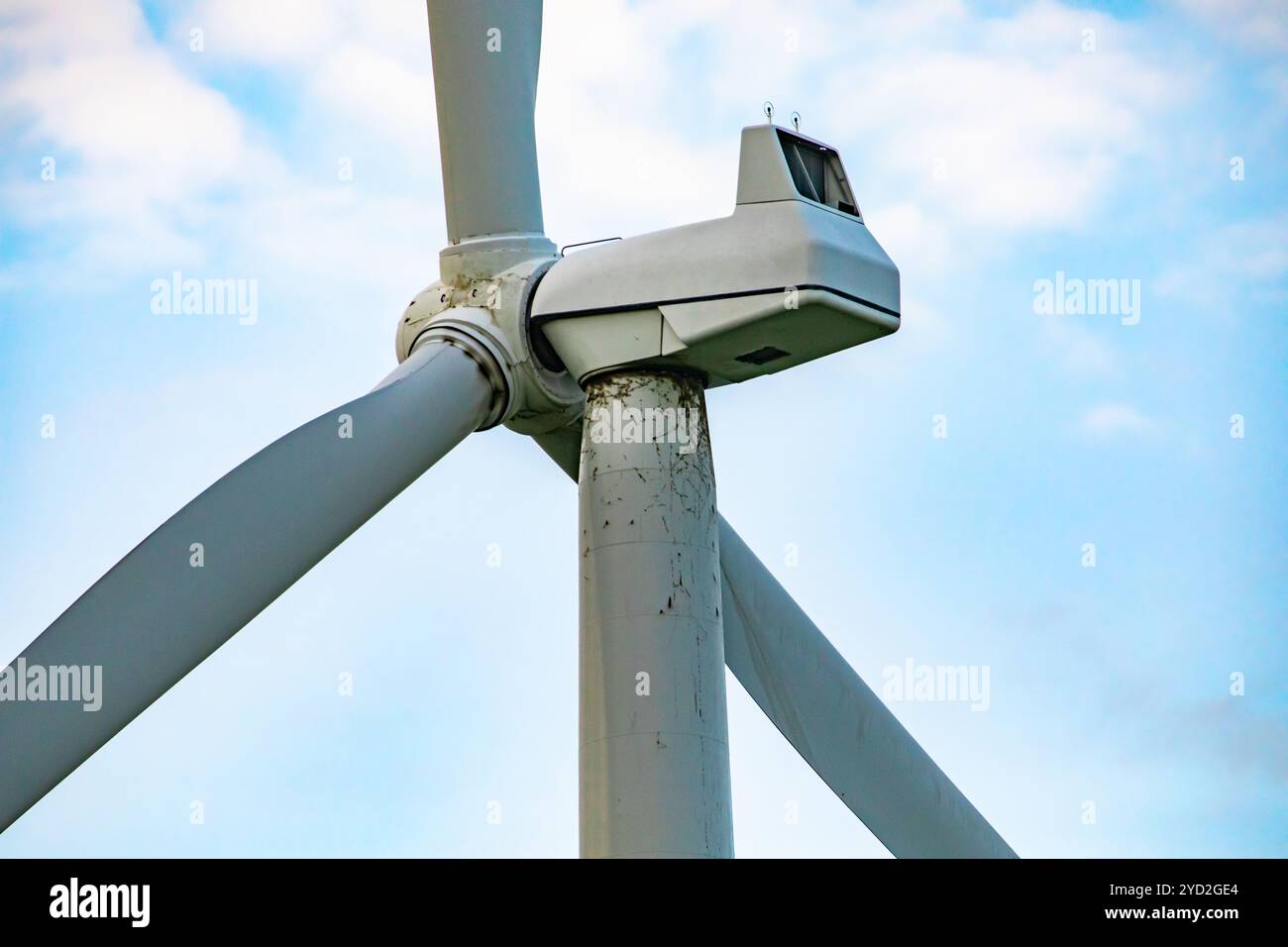 Un primo piano e uno scatto laterale sul dettaglio superiore di una turbina eolica, che mostra la navicella e l'anemometro. Energia rinnovabile moderna, pulita e ecologica. Con il poliziotto Foto Stock