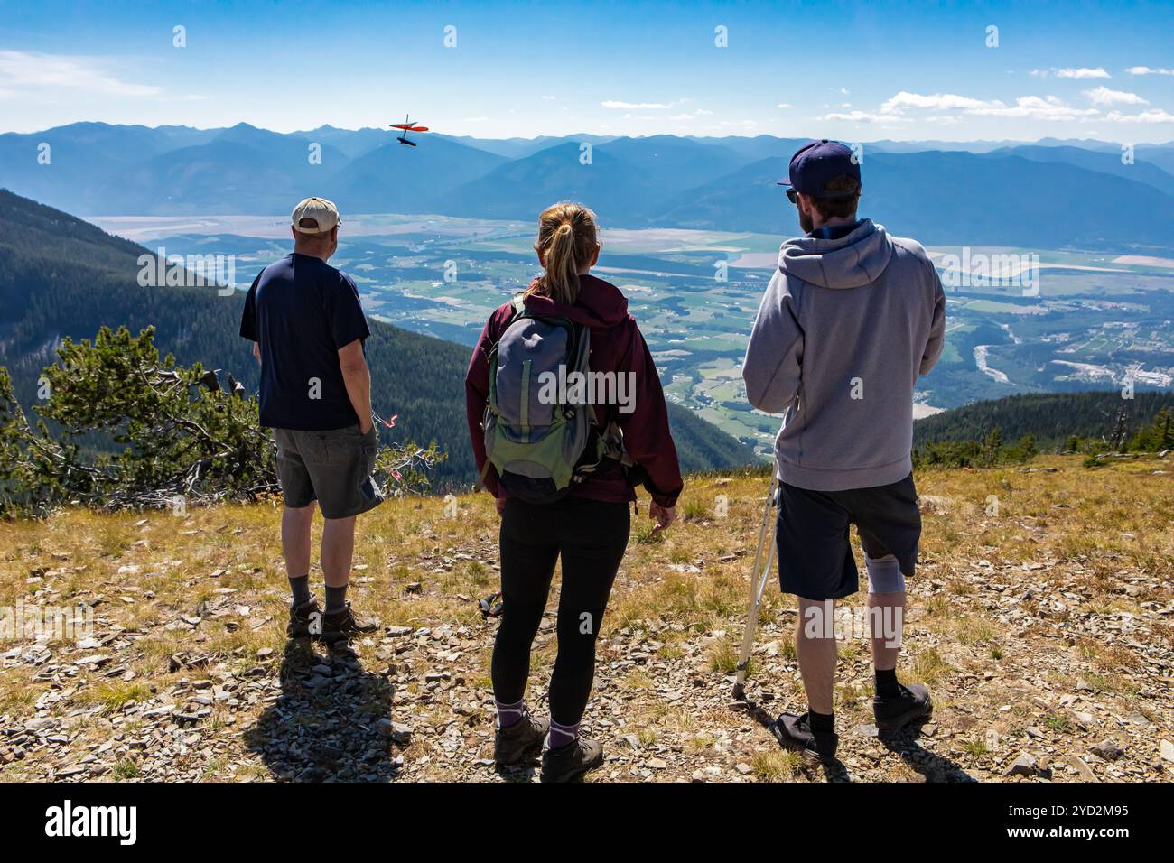 Gli amici guardano il deltaplano dalla cima della montagna Foto Stock