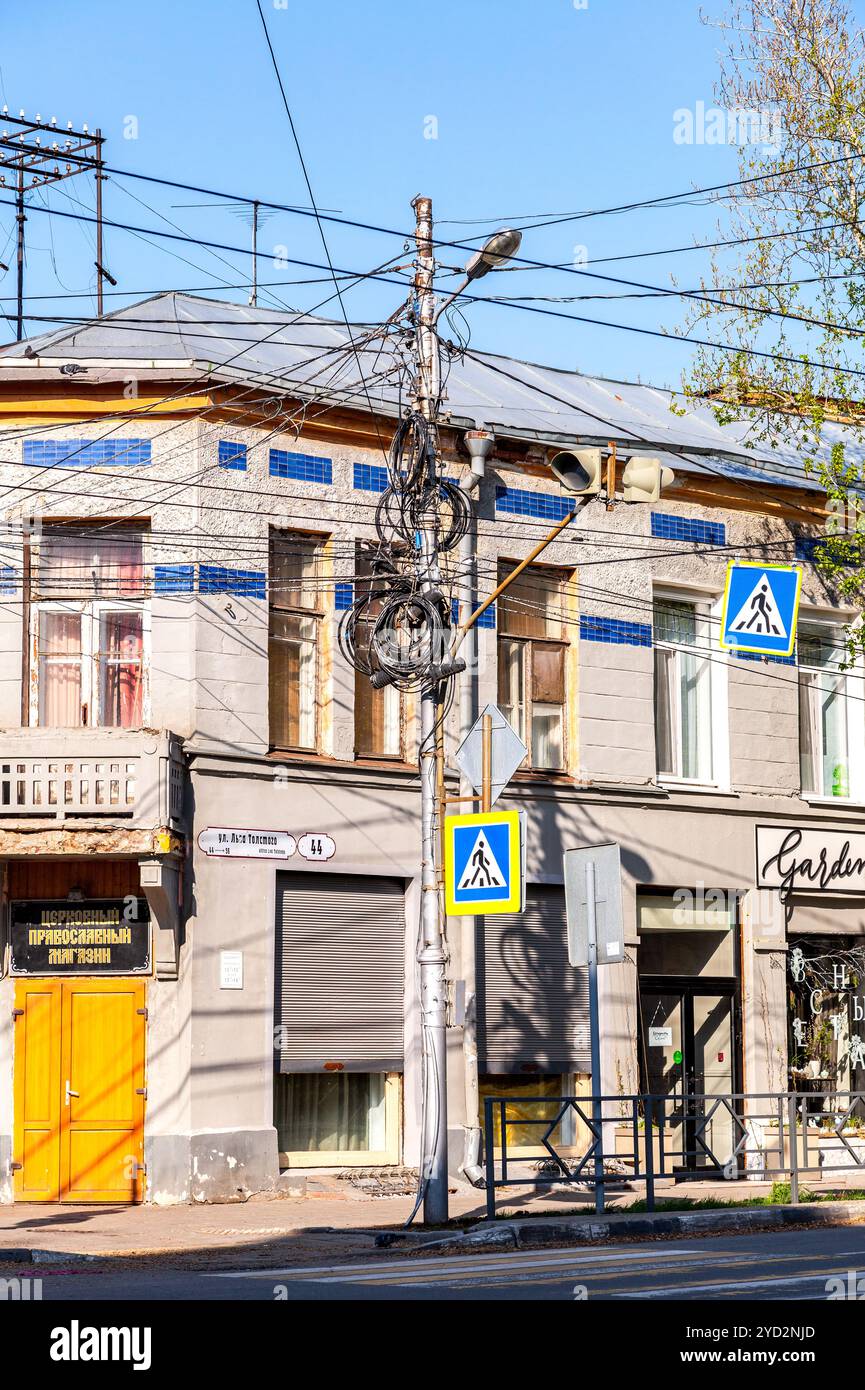Diversi cavi elettrici e di comunicazione sono fissati sul palo Foto Stock