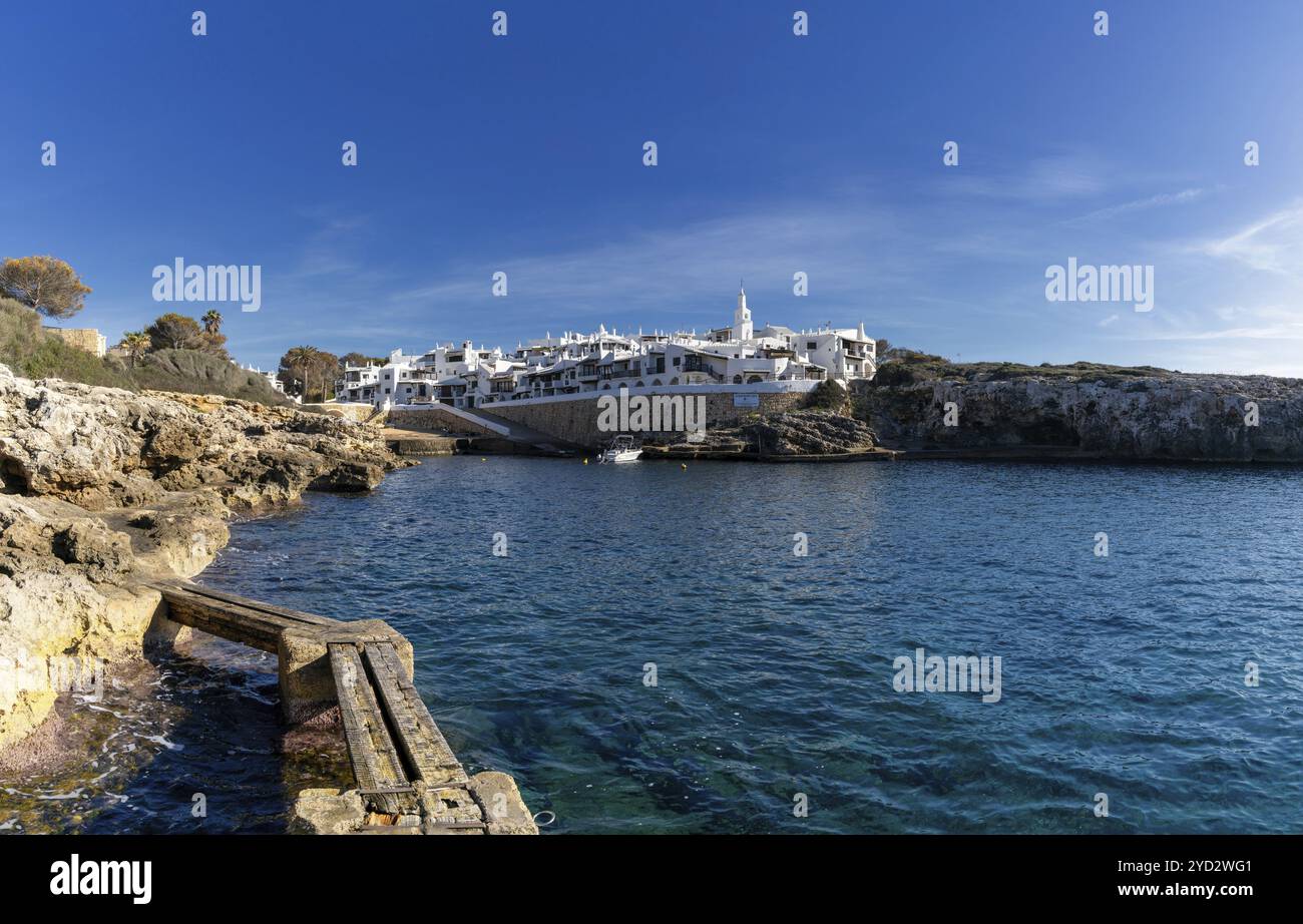 Binibeca Vell, Spagna, 24 gennaio 2024: Baia idilliaca e il villaggio imbiancato di Binibeca Vell a Minorca, Europa Foto Stock