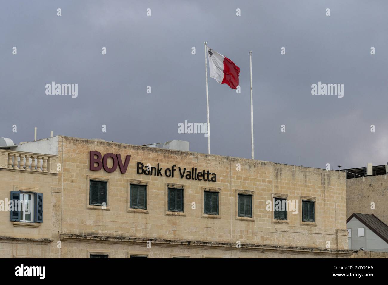 La Valletta, Malta, 23 dicembre 2023: Veduta dell'edificio della sede della Bank of Valletta a la Valletta con la bandiera maltese sul tetto, Europa Foto Stock