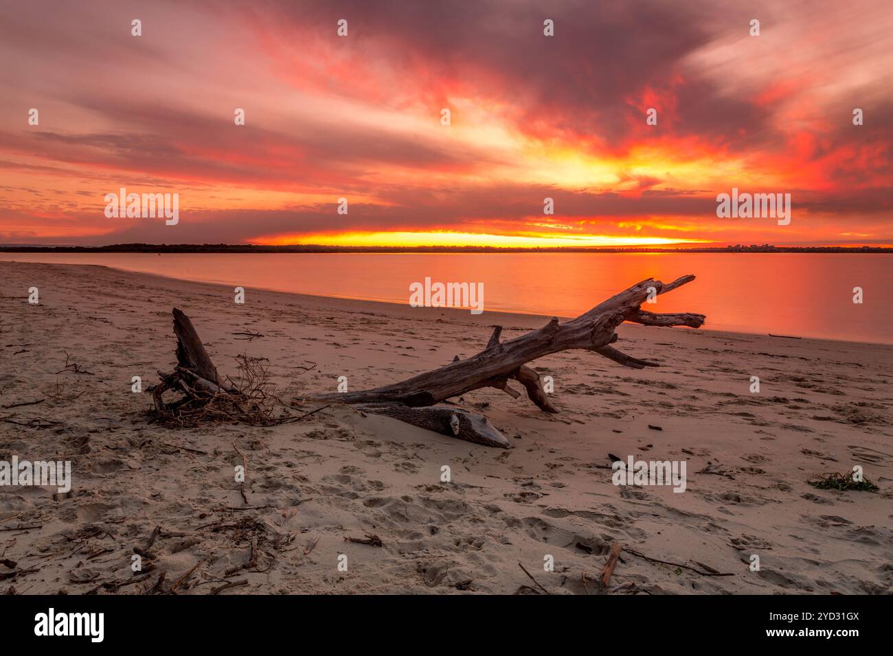 Vivaci colori arancio e rosso del tramonto sulla spiaggia Foto Stock