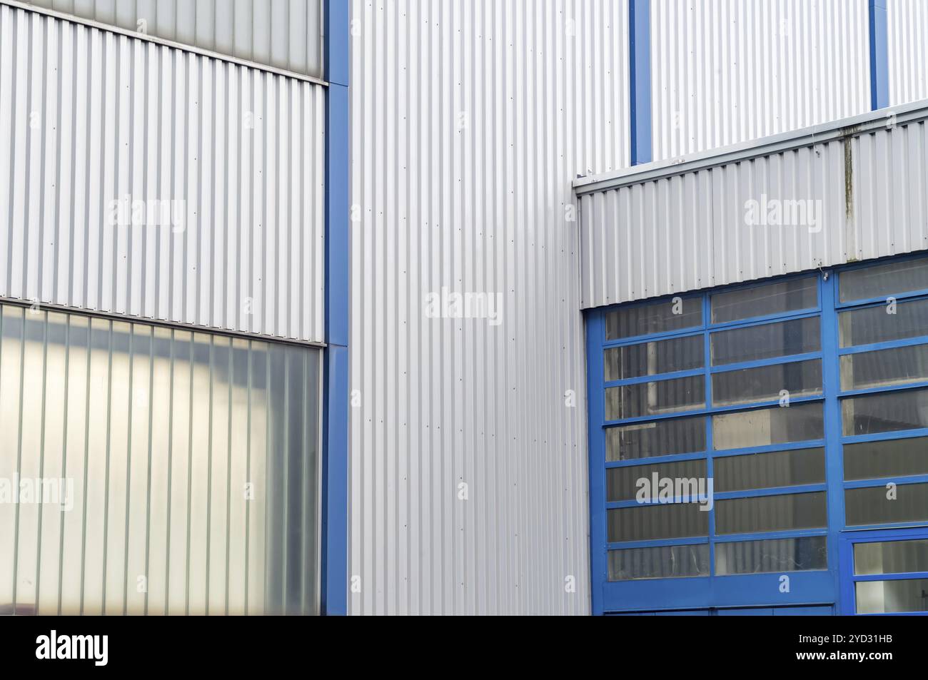 Edificio industriale con pareti in acciaio ondulato e telai per finestre blu Foto Stock