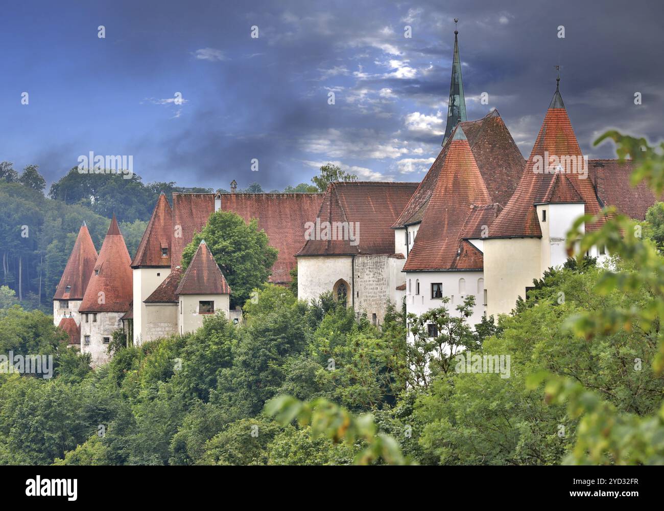 Gli edifici storici del castello di Burghausen si innalzano tra verdi alberi decidui, interessante paesaggio panoramico contro un cielo spettacolare, primaverile, Burghausen, Upper Foto Stock