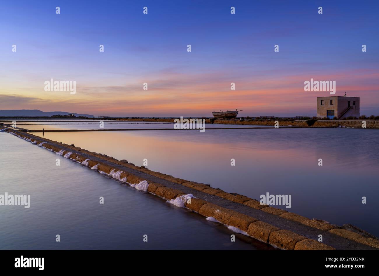 Vista panoramica di calmi bacini salati e appartamenti vicino a Trapani e Paceco al tramonto Foto Stock