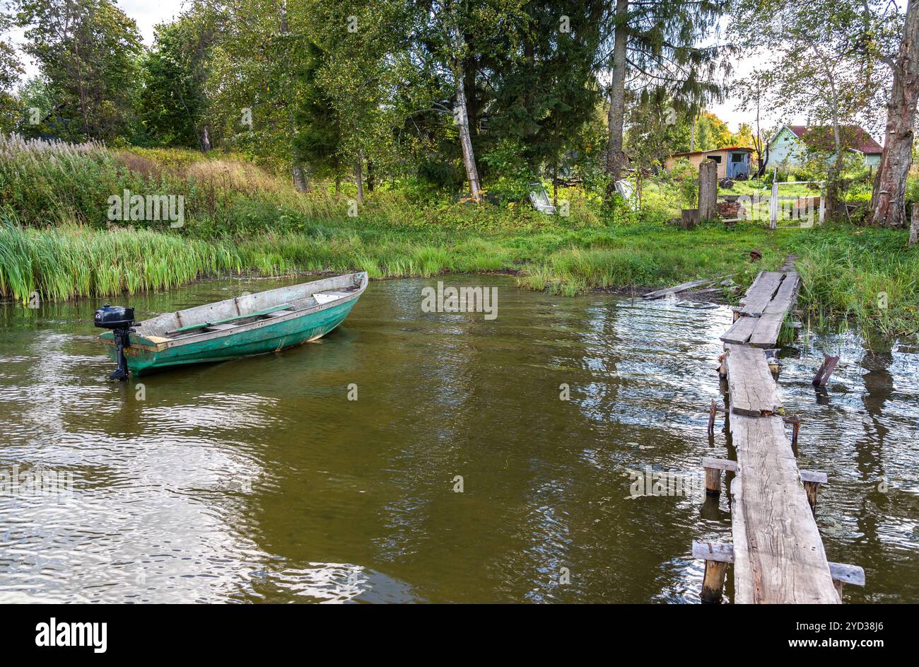 Barca da pesca in plastica con motore sulla riva del lago in estate Foto Stock