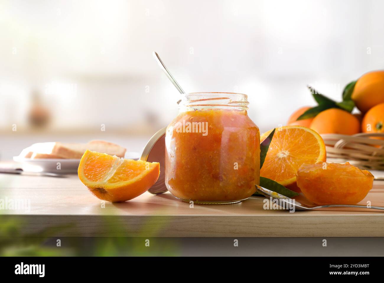 Barattolo di marmellata d'arancia e frutta su panca in legno e cucina bianca sullo sfondo. Vista frontale. Foto Stock