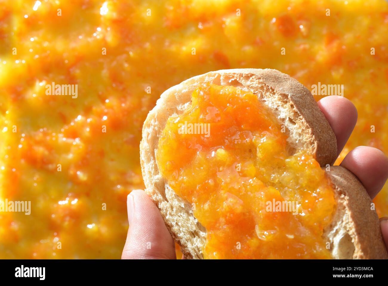 Brindisi a mano con marmellata all'arancia e sfondo con marmellata. Vista dall'alto. Foto Stock