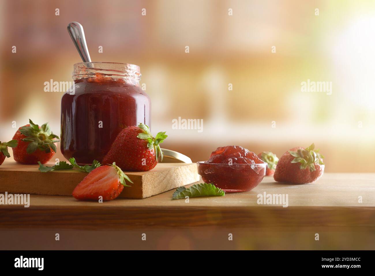 Barattoli con marmellata di fragole su legno e frutta intorno su un tavolo di legno e sfondo rustico della cucina. Vista frontale. Foto Stock