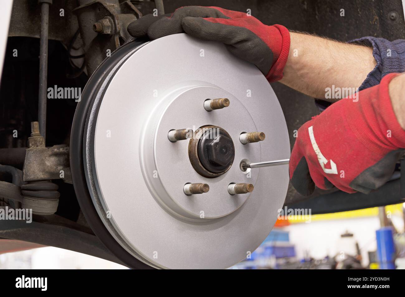 Primo piano dell'installazione di un nuovo disco del freno in un'auto moderna Foto Stock