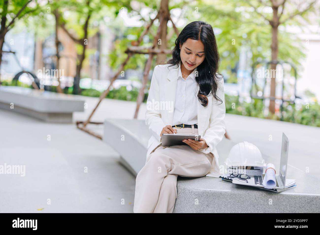 Giovane ingegnere intelligente che utilizza la progettazione di schizzi su tablet nel parco naturale. Progettista di progetti energetici a risparmio ambientale donne lavoratrici . Foto Stock