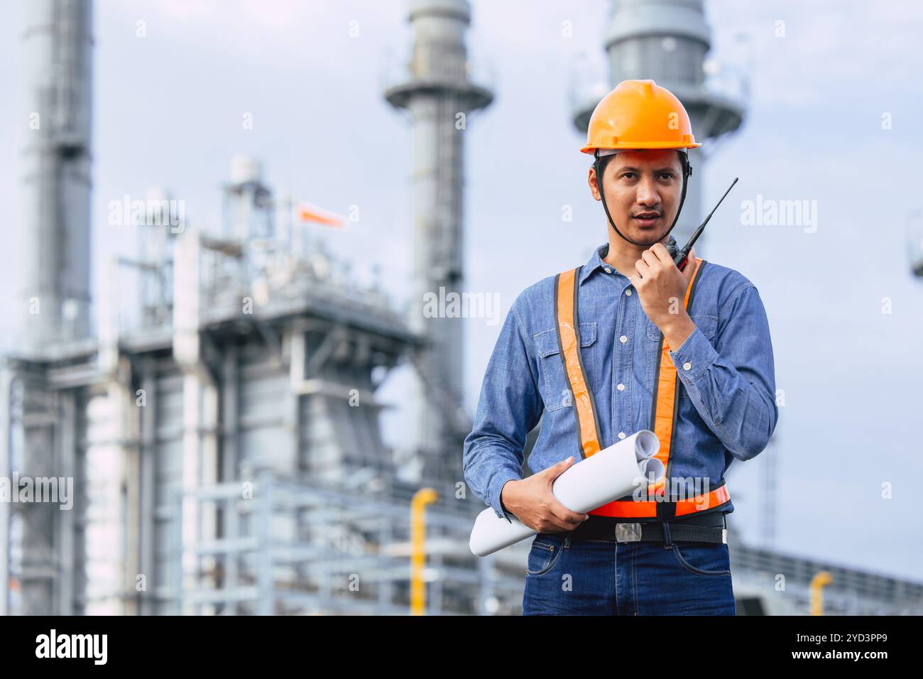 Ingegnere del settore della raffineria petrolifera che lavora contro la fabbrica industriale di energia di petrolio e gas. Lavoratore professionista del settore delle centrali elettriche petrolchimiche Foto Stock