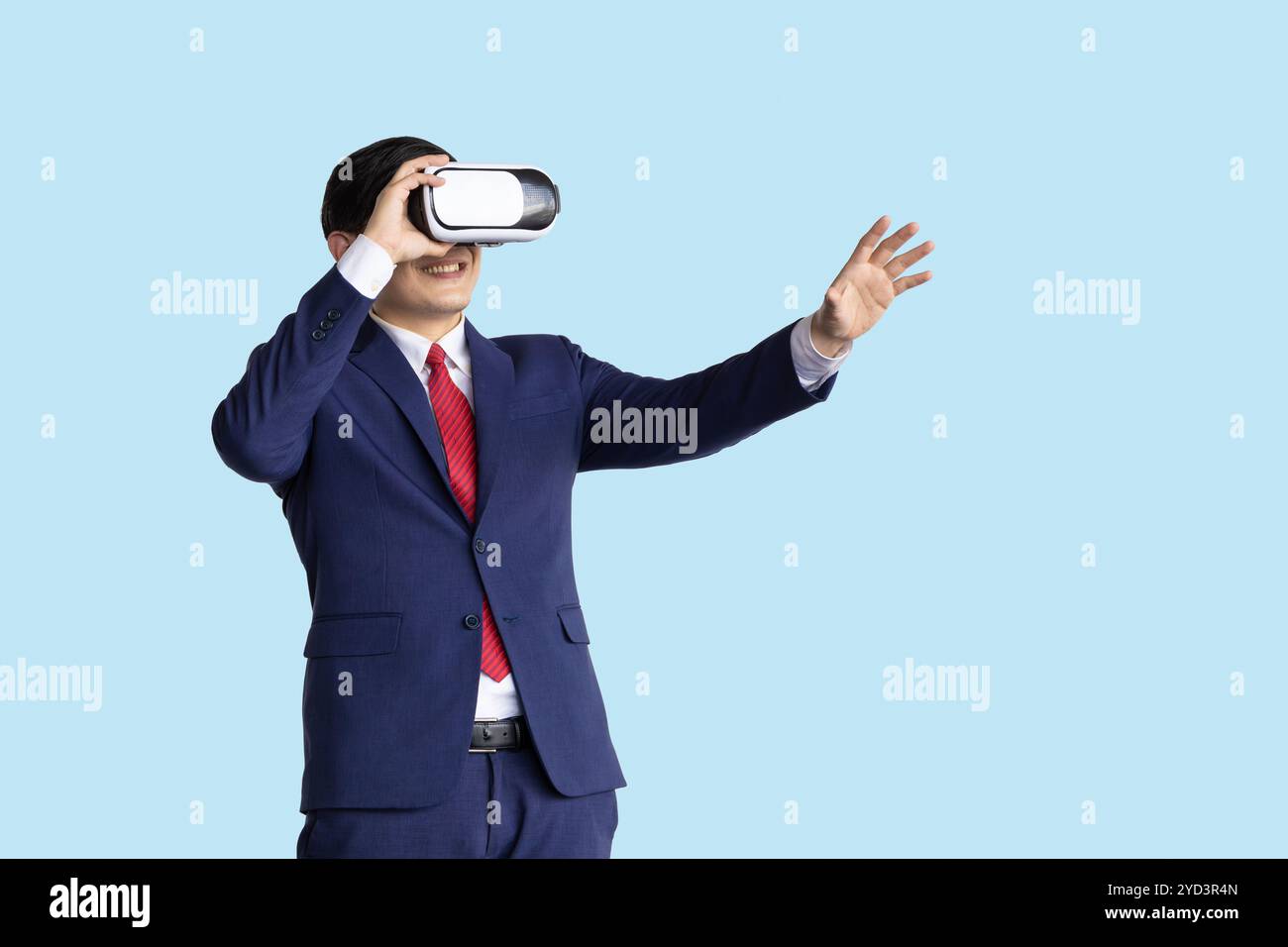 Uomo d'affari che utilizza la tecnologia Visual VR isolata su sfondo blu, uomini d'affari che utilizzano un moderno dispositivo con tecnologia olografica. Foto Stock