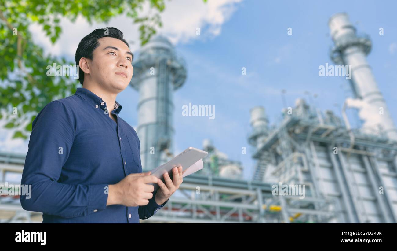 Imprenditore leader che investe nell'industria delle raffinerie di petrolio con tablet Blueprint per pianificare gli investimenti nell'industria petrolifera. Foto Stock