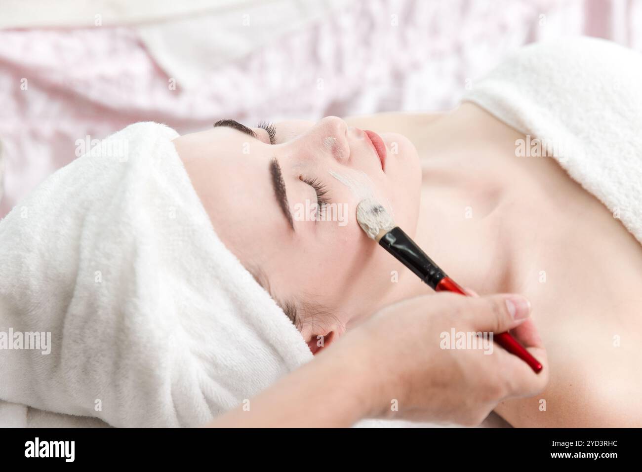 Estetista cosmetologo applica maschera crema di erbe con spatola, procedura professionale in un salone di bellezza per il cliente. Cura della pelle e cosmetologia Foto Stock