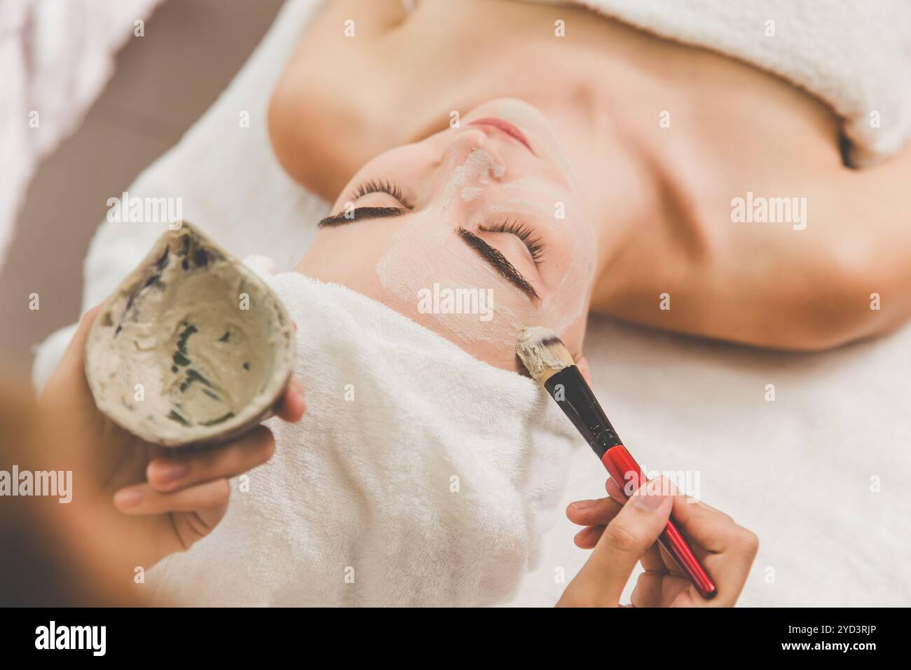 Estetista cosmetologo applica maschera crema di erbe con spatola, procedura professionale in un salone di bellezza per il cliente. Cura della pelle e cosmetologia Foto Stock