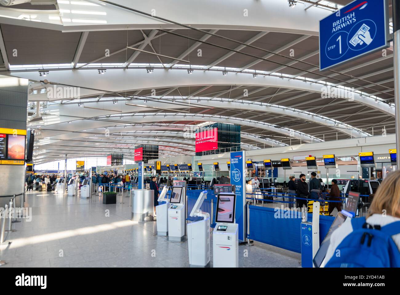 All'interno del Terminal 5, partenze dall'aeroporto Heathrow di Londra, Regno Unito. I passeggeri fanno la fila al check-in per i voli della British Airways Foto Stock