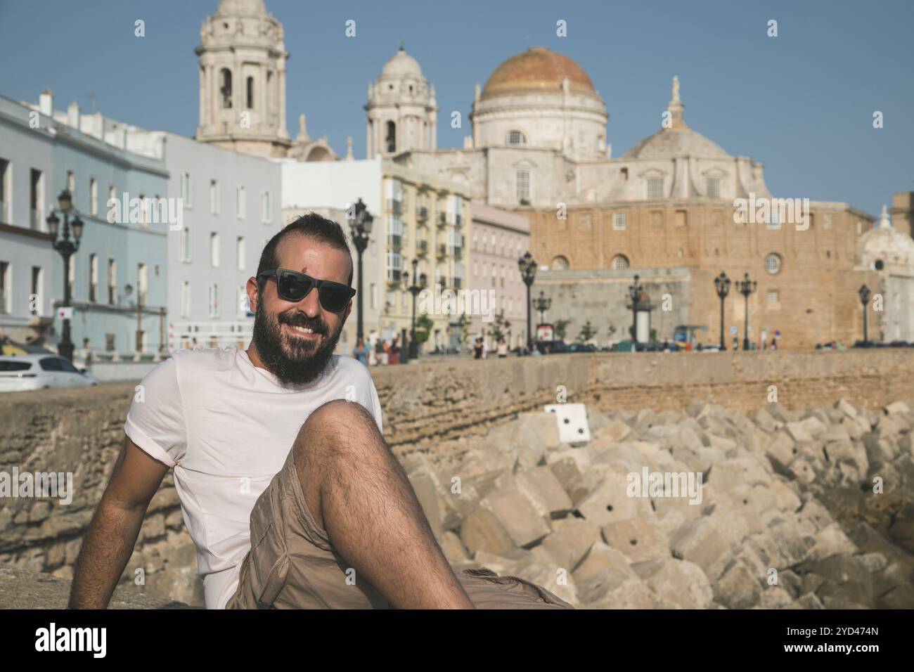 uomo di mezza età sorridente di fronte a un'antica città Foto Stock