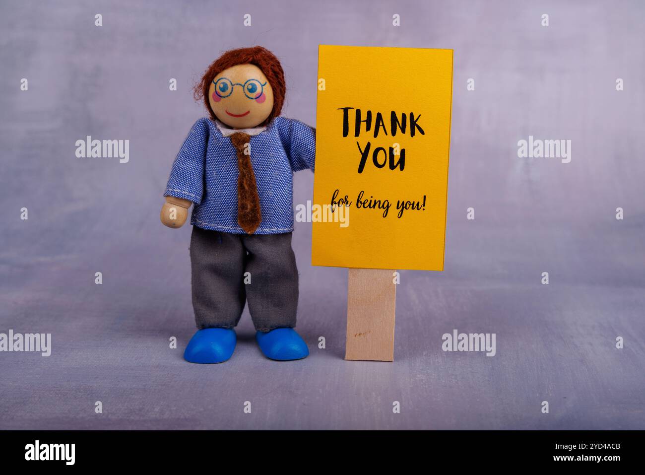 Un colorato giocattolo in legno ha un cartello giallo con una frase motivazionale, che rappresenta incoraggiamento e positività in modo divertente e coinvolgente Foto Stock