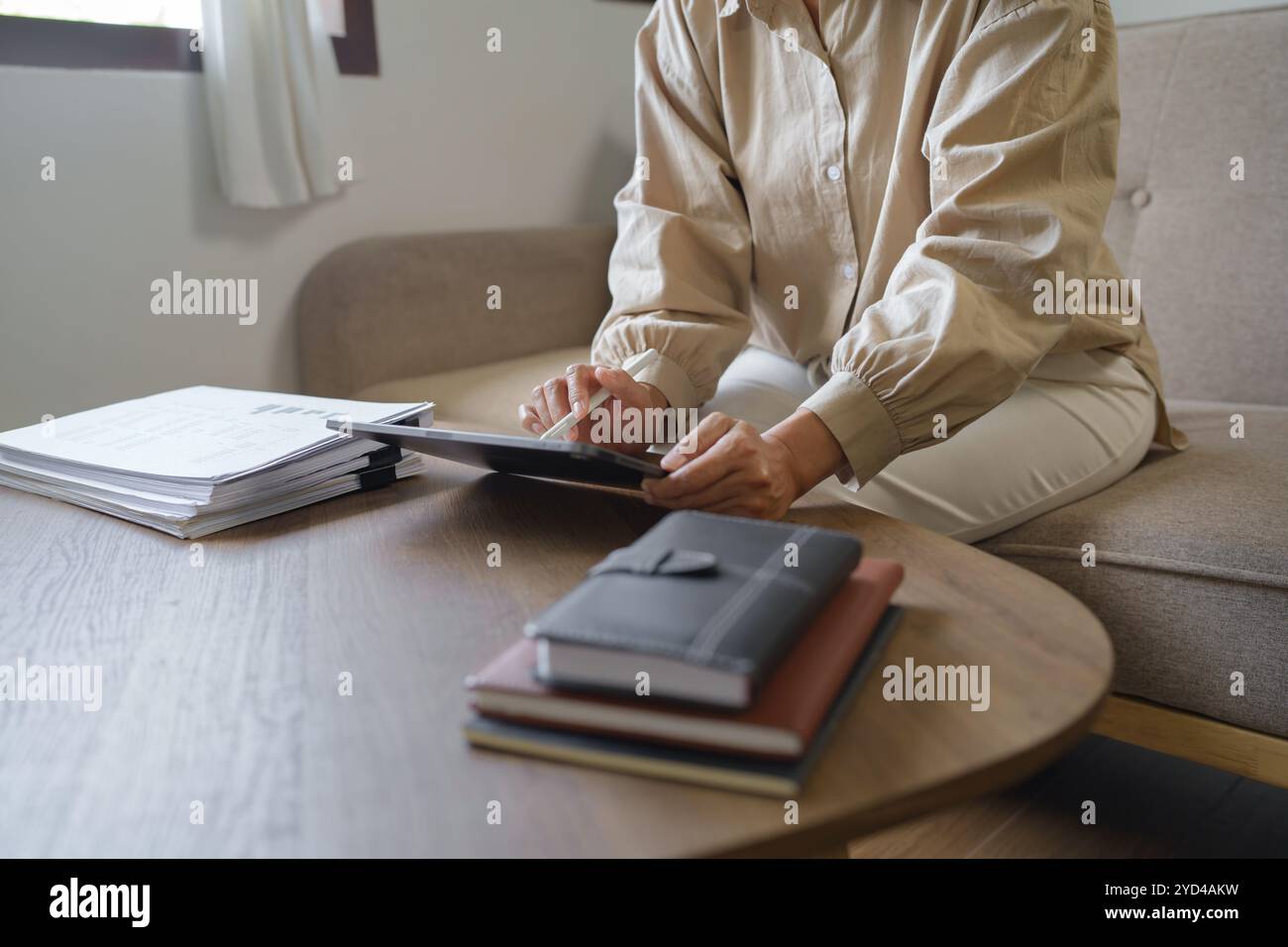 Immagine di donna calcolare la fattura fiscale a casa, riassumendo le tasse, planando il denaro. Foto Stock