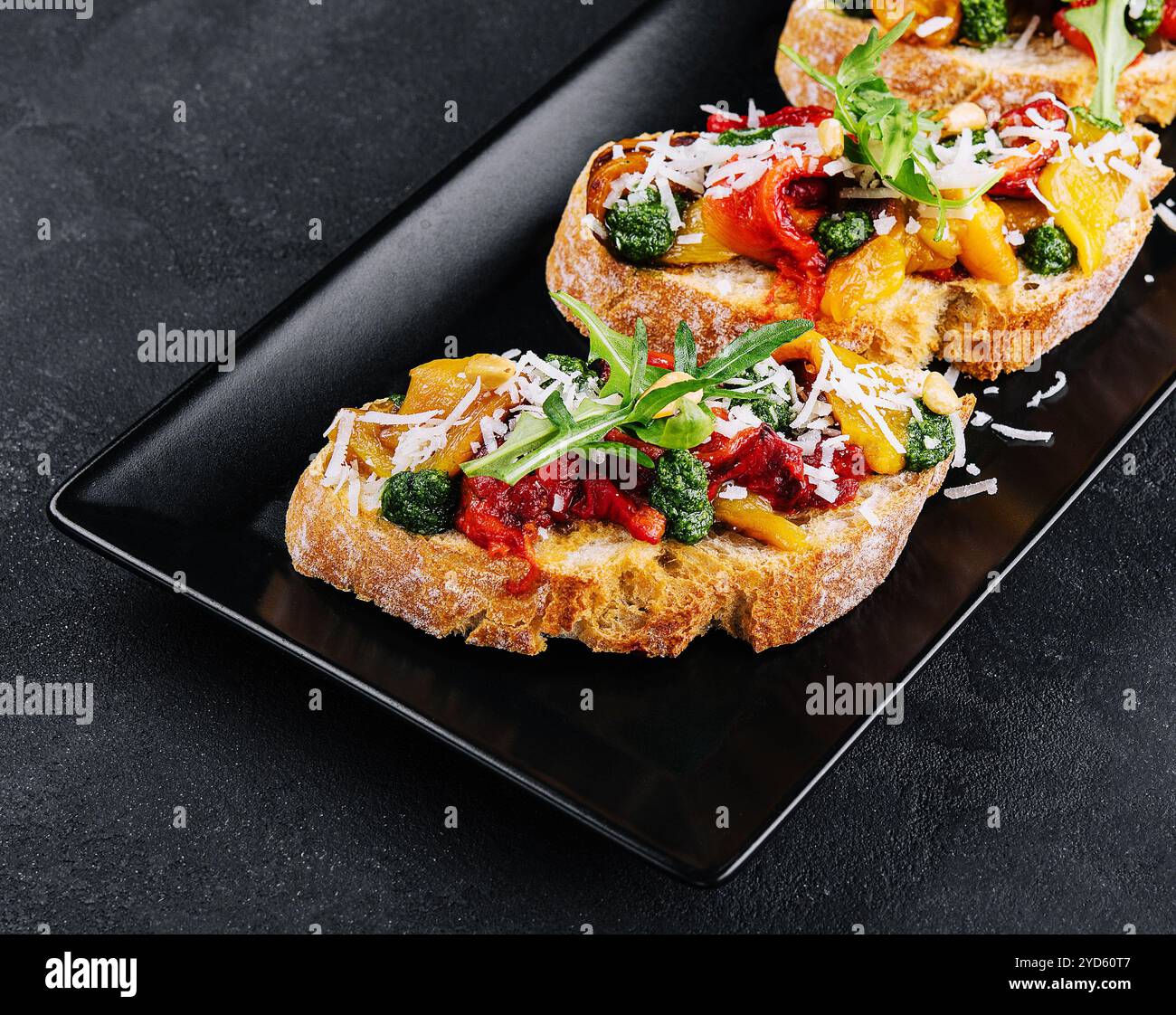 Bruschetta con peperoni arrostiti, pesto e parmigiano Foto Stock