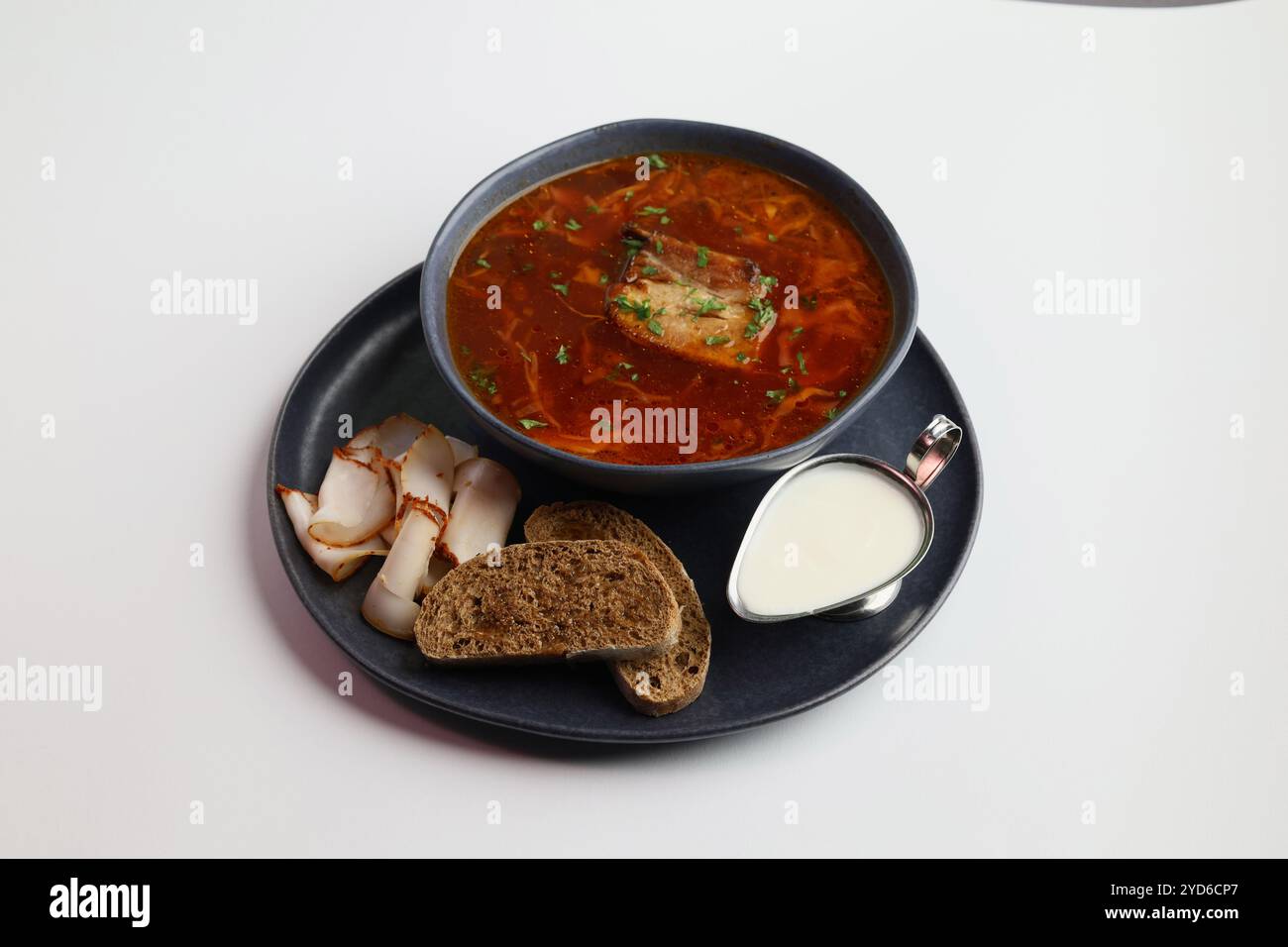 Borscht tradizionale ucraino . Ciotola di zuppa di barbabietole rosse borscht con panna bianca e pane di segale con lardo. Barbabietola zuppa deliziosa. Ukr. Tradizionale Foto Stock