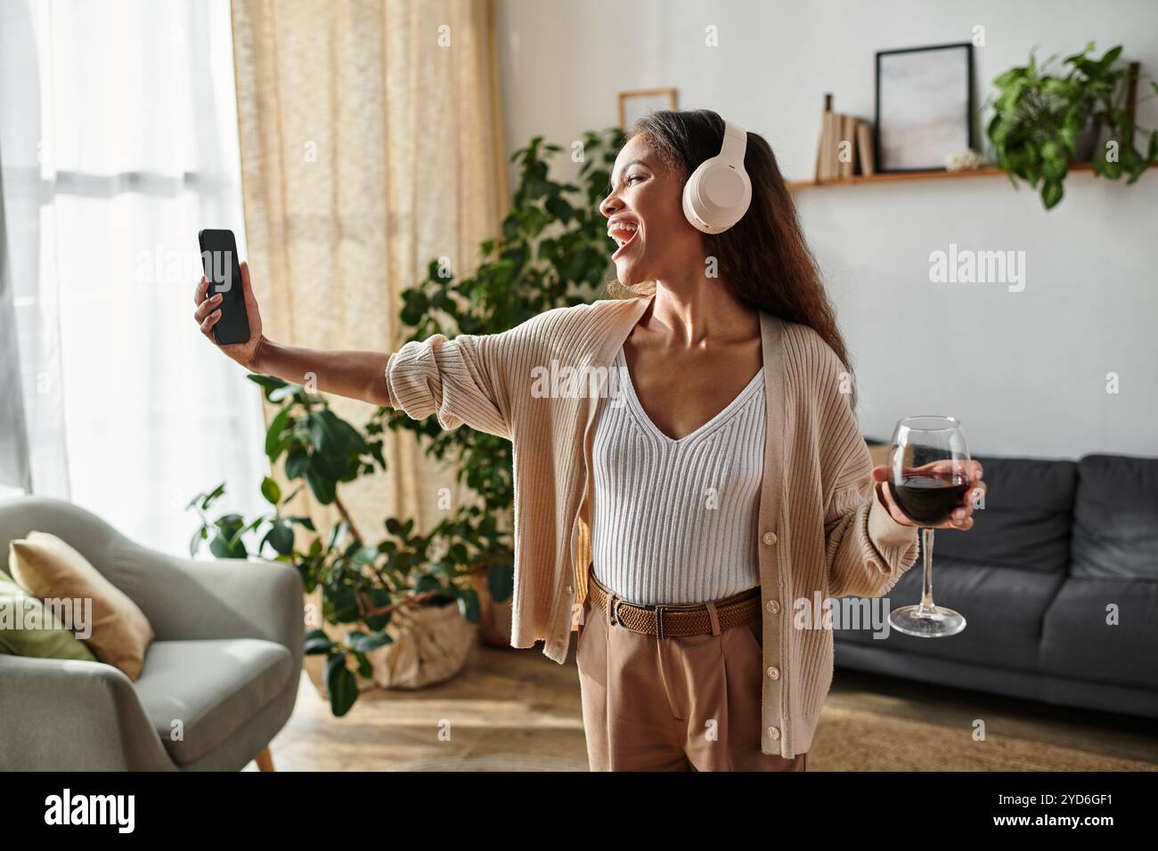 Questa donna esprime la sua felicità mentre cattura un momento divertente con il suo drink in mano. Foto Stock